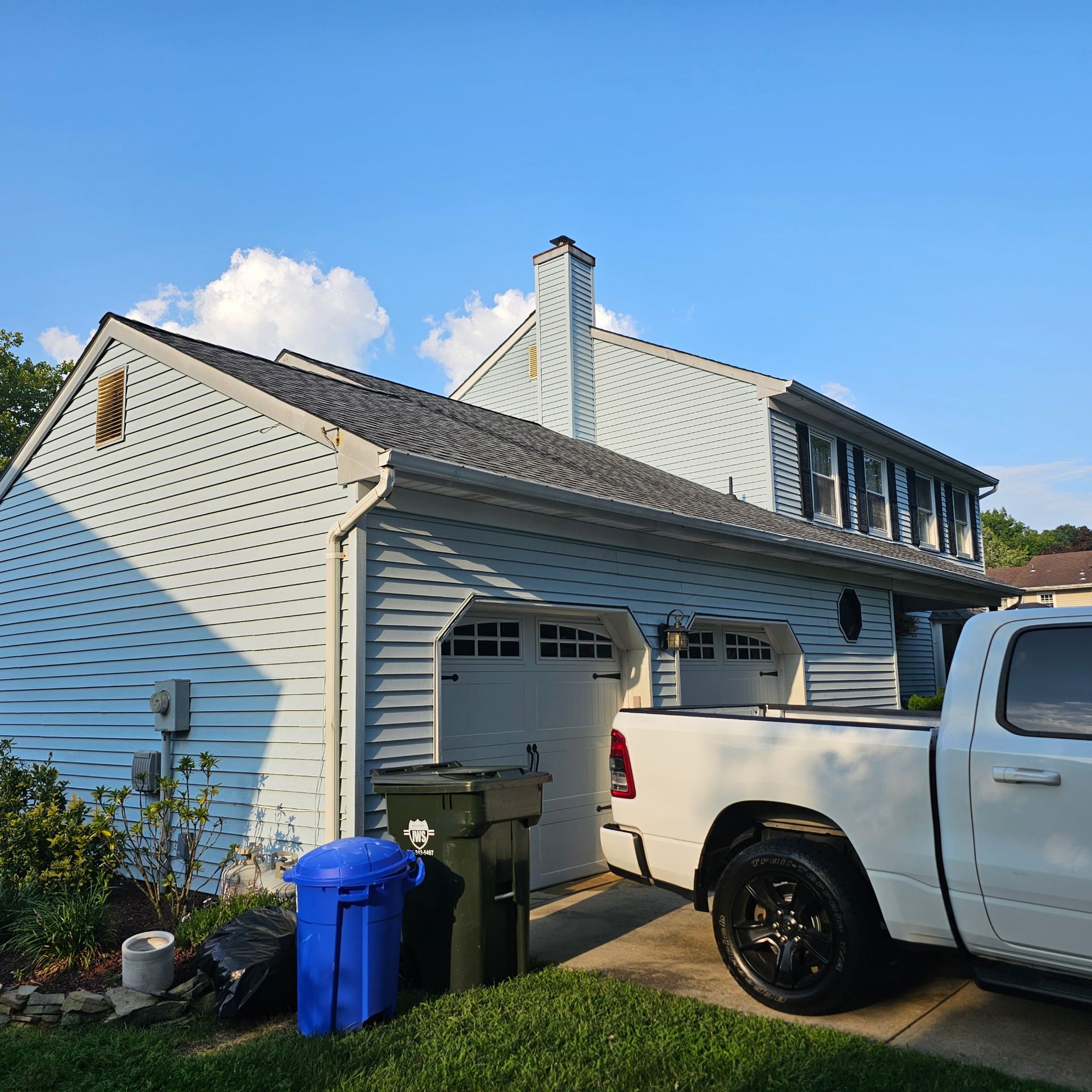 A white truck is parked in front of a house