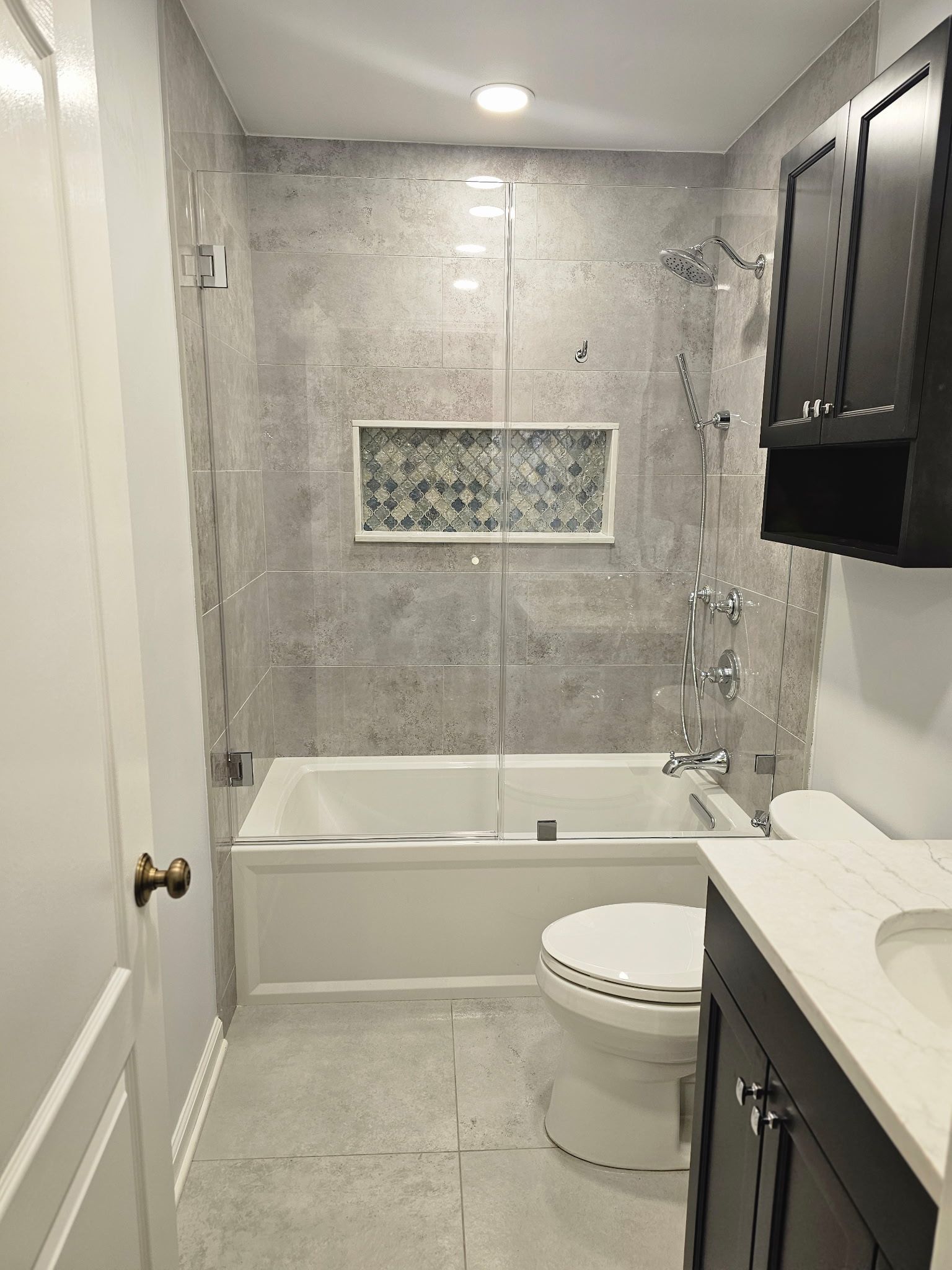 A bathroom with a tub , toilet , sink and shower.