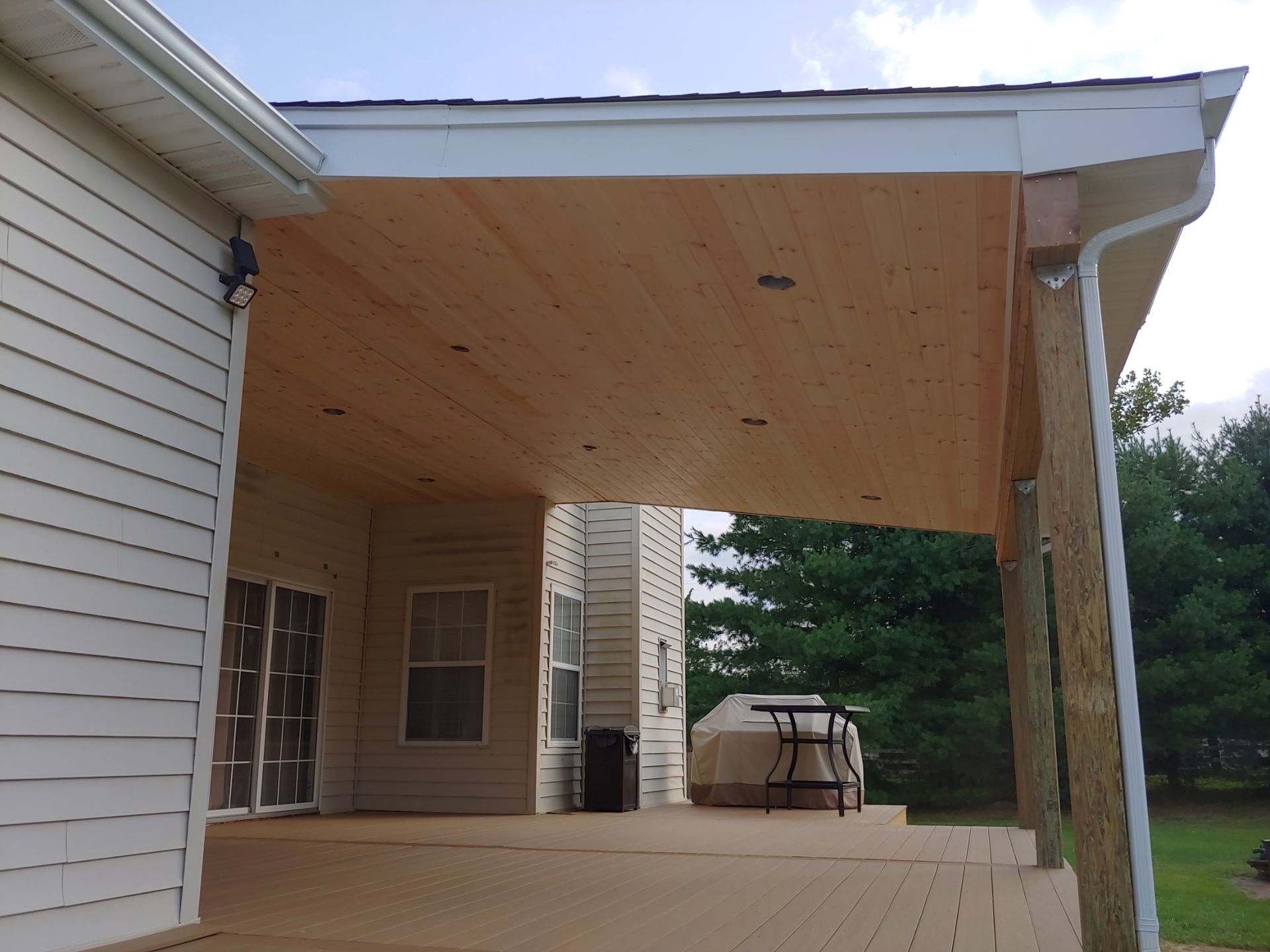 A white house with a wooden deck underneath it