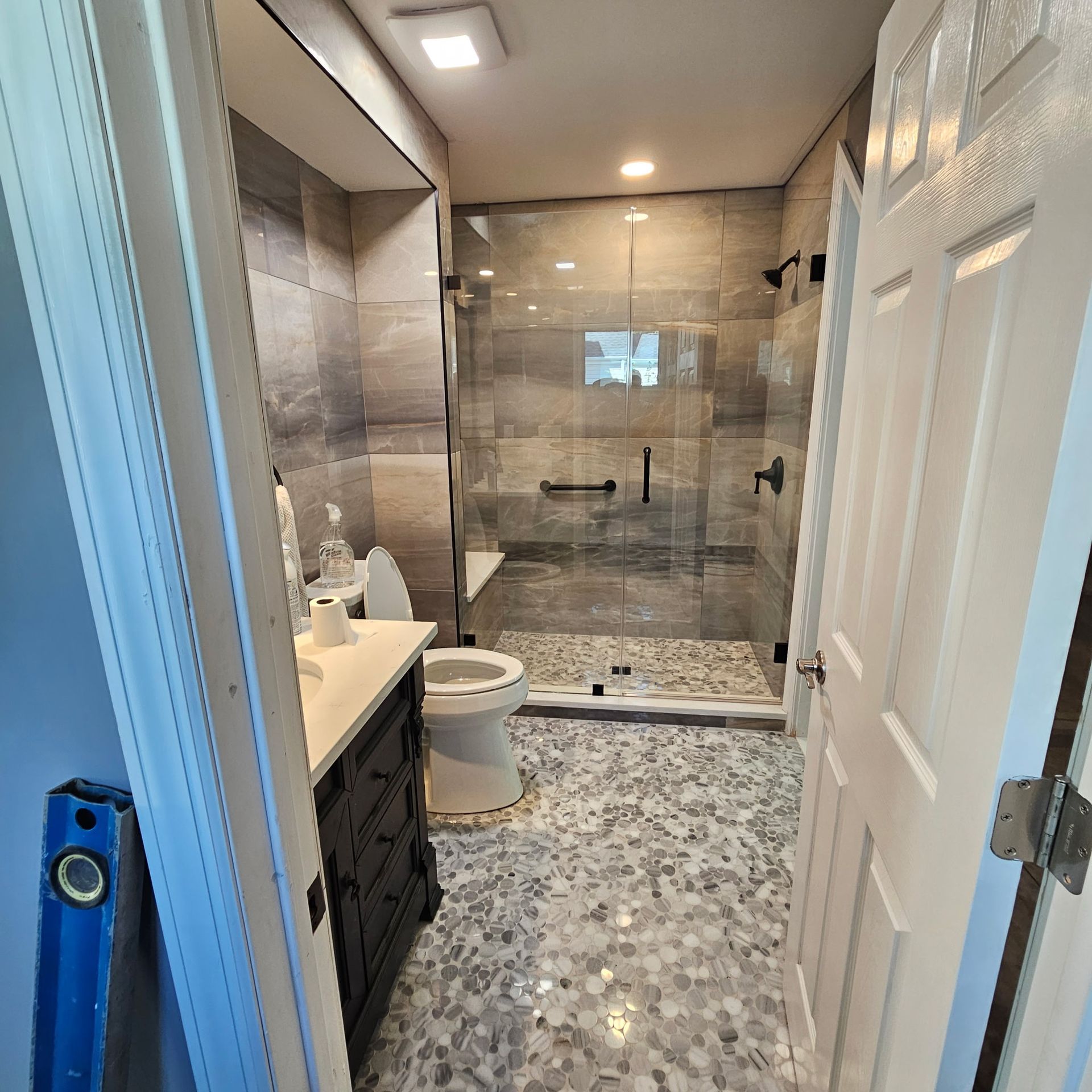 A bathroom with a toilet , sink , and walk in shower.