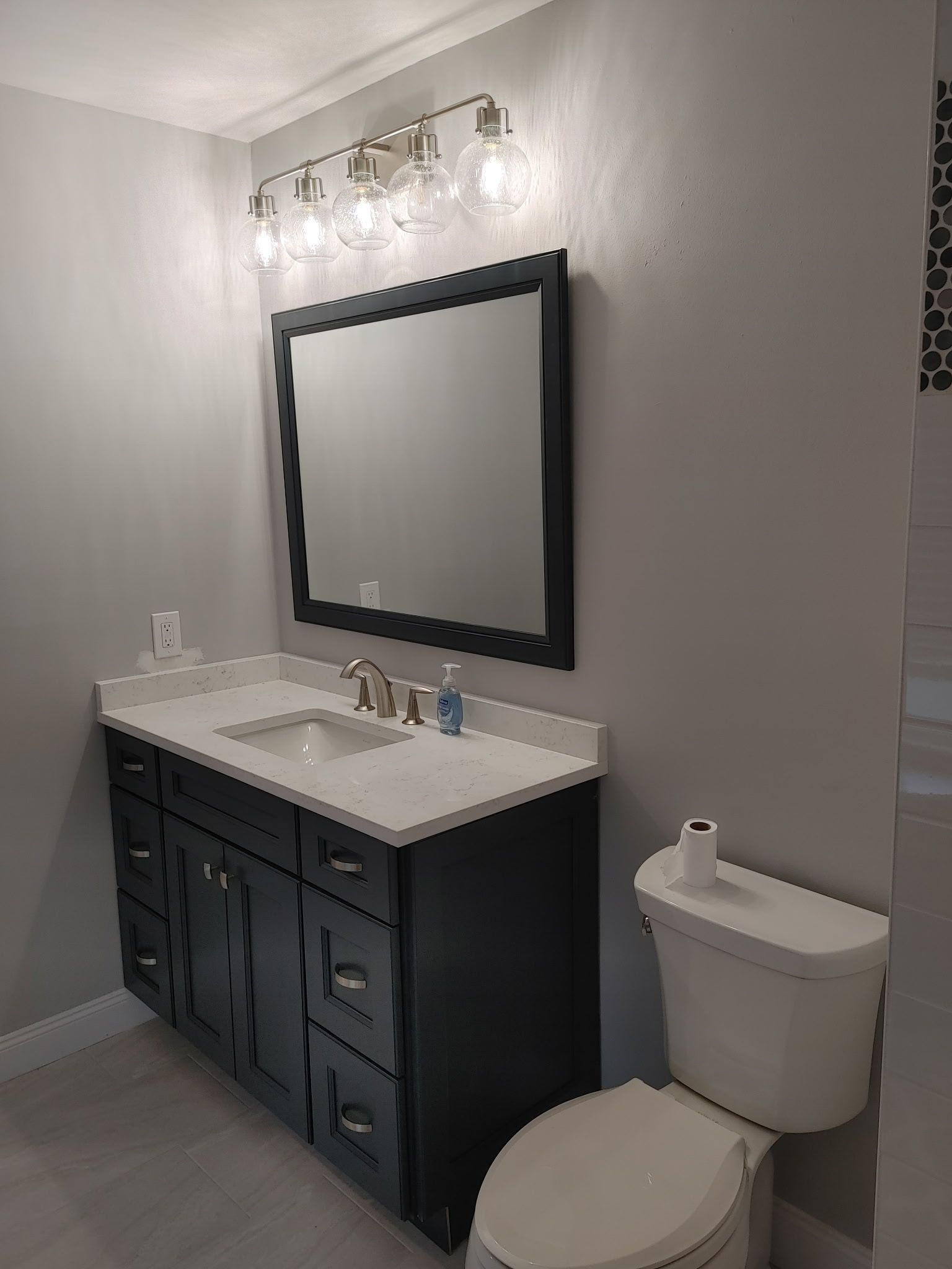 A bathroom with a sink , toilet and mirror.