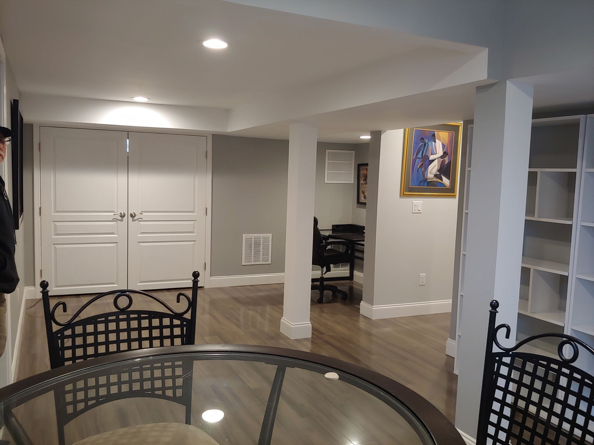A basement with a table and chairs and a painting on the wall.
