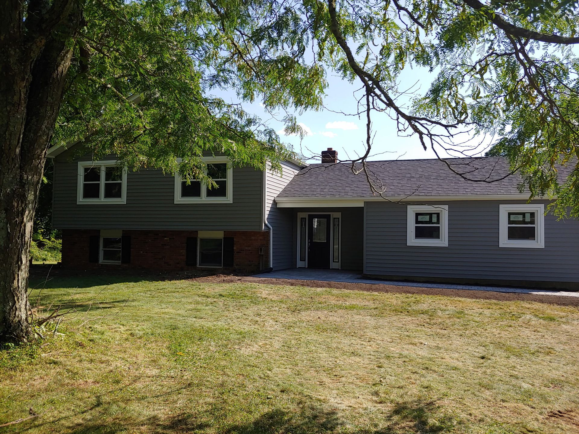 A large house with a lot of windows and a tree in front of it.