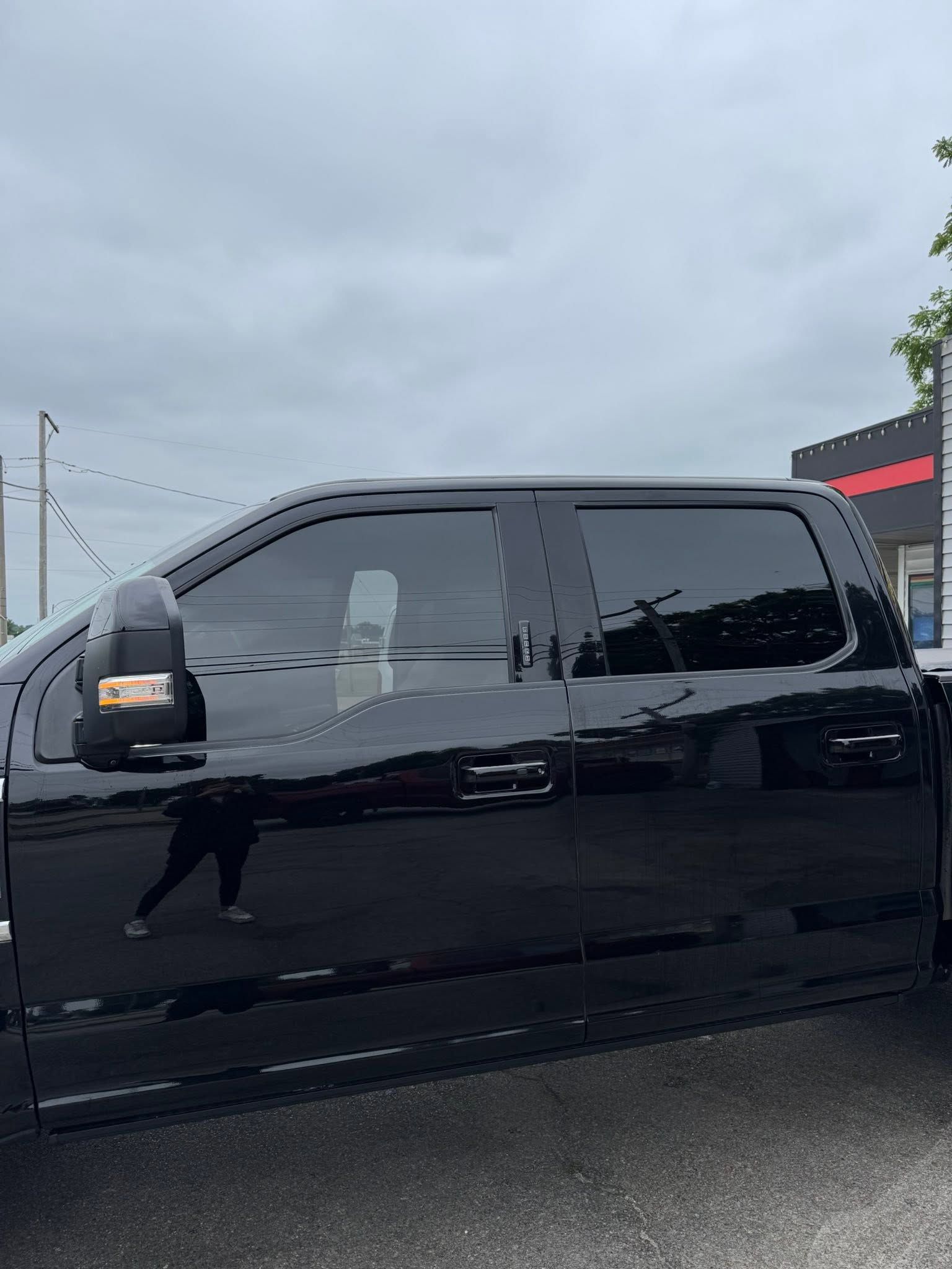Black pickup truck parked outdoors under a cloudy sky.