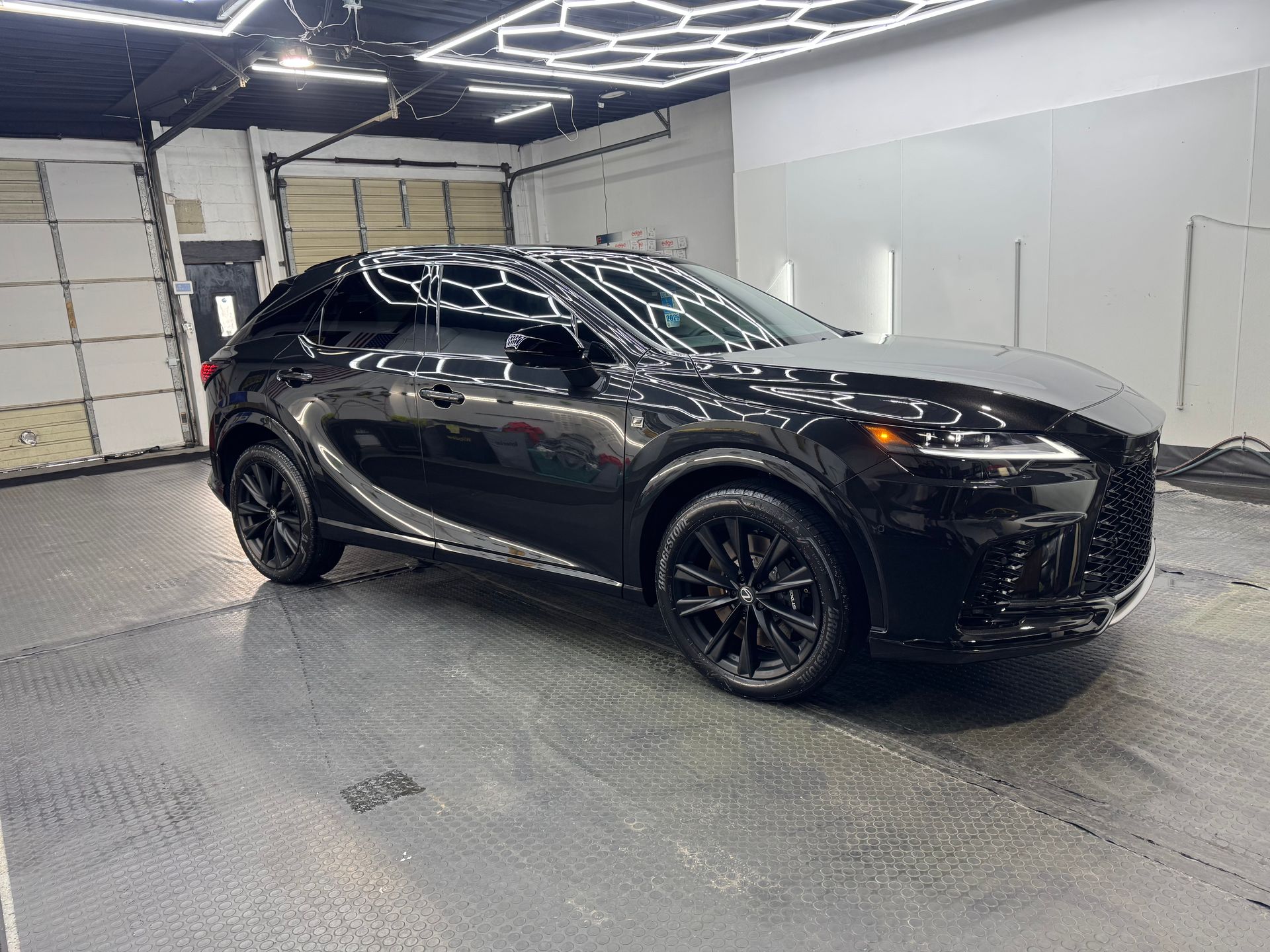 Black SUV in a bright garage with overhead lights and white walls