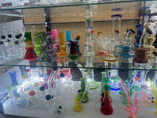 A glass display case filled with a variety of glass pipes.