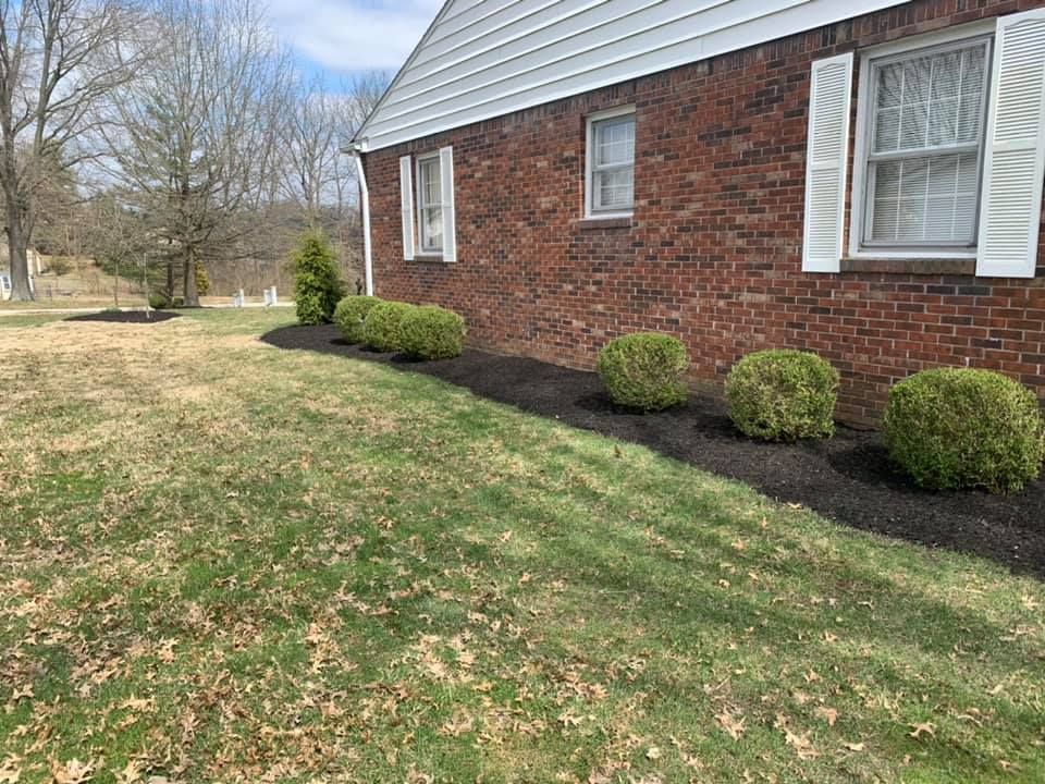 A brick house with a lush green lawn in front of it.