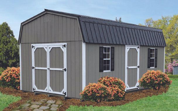 Grey shed with white trim, black roof, and shrubs in front.