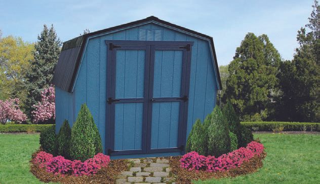 Blue barn shed with dark blue doors and trim, set in a garden with brick path and landscaping.