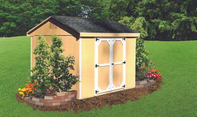 Yellow shed with white-framed double doors, nestled in a flower bed on a green lawn. Black roof.
