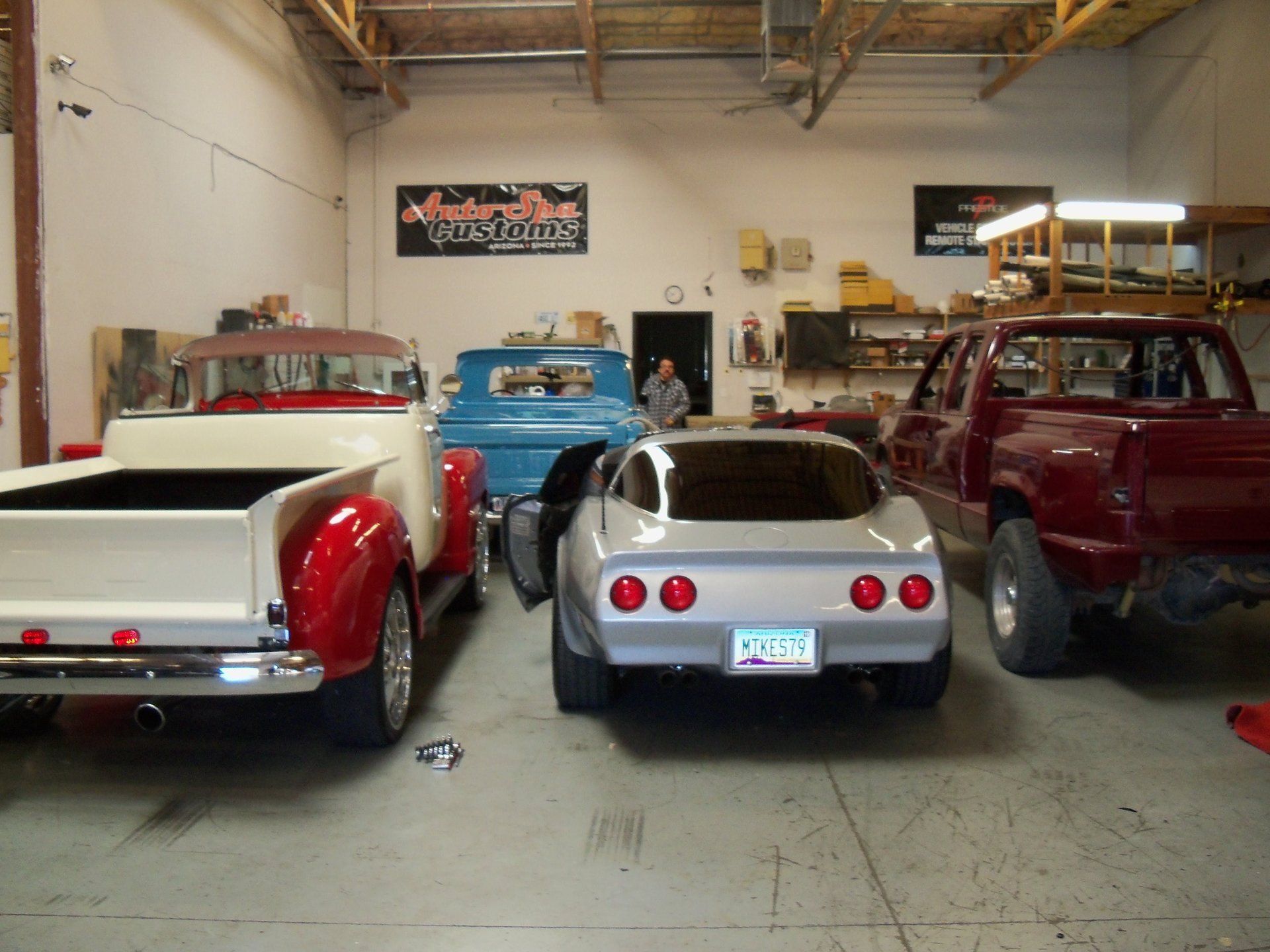 A row of old cars are parked in a garage.