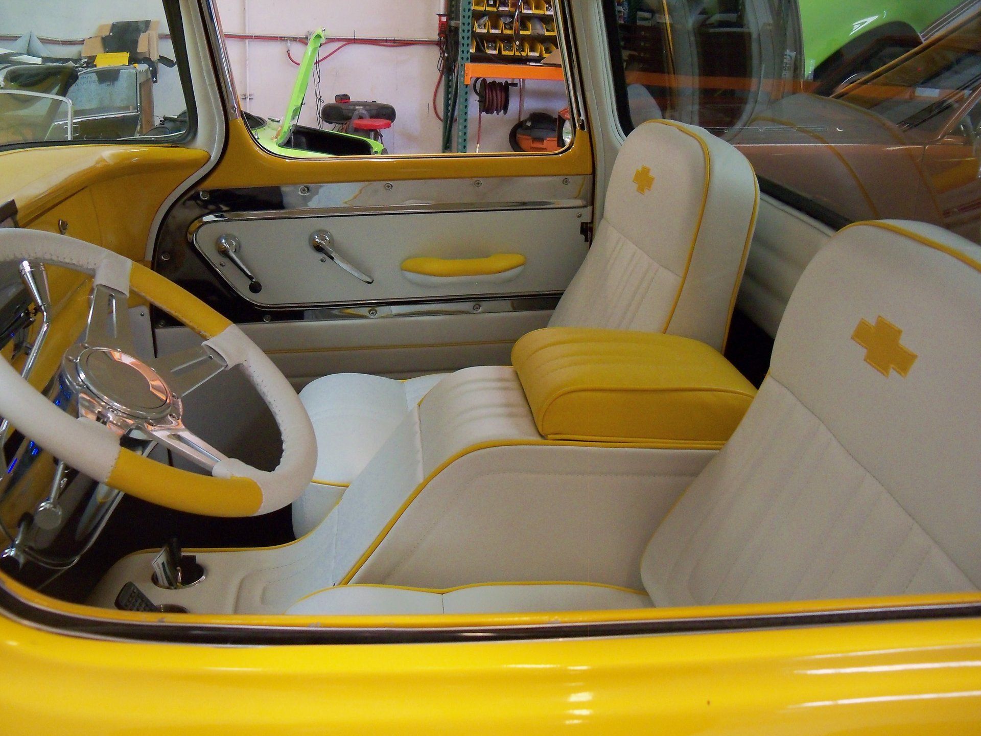 A yellow car with white seats and a yellow steering wheel.