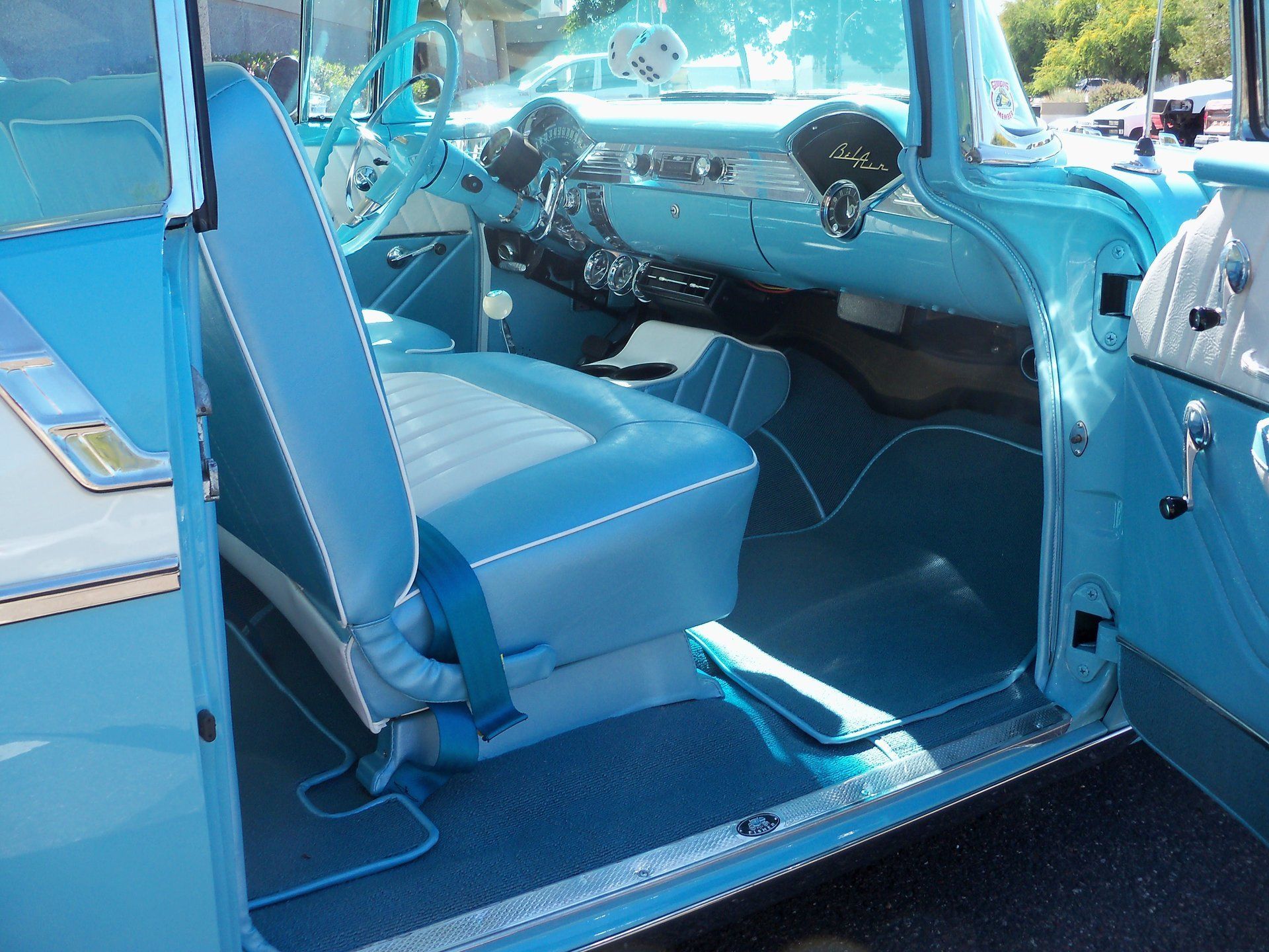 The inside of a blue car with the door open.
