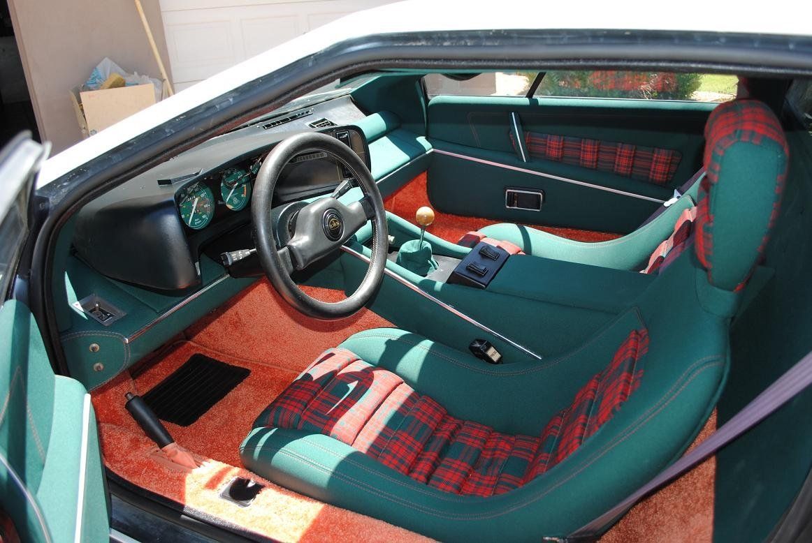 A white car with green seats and a steering wheel.