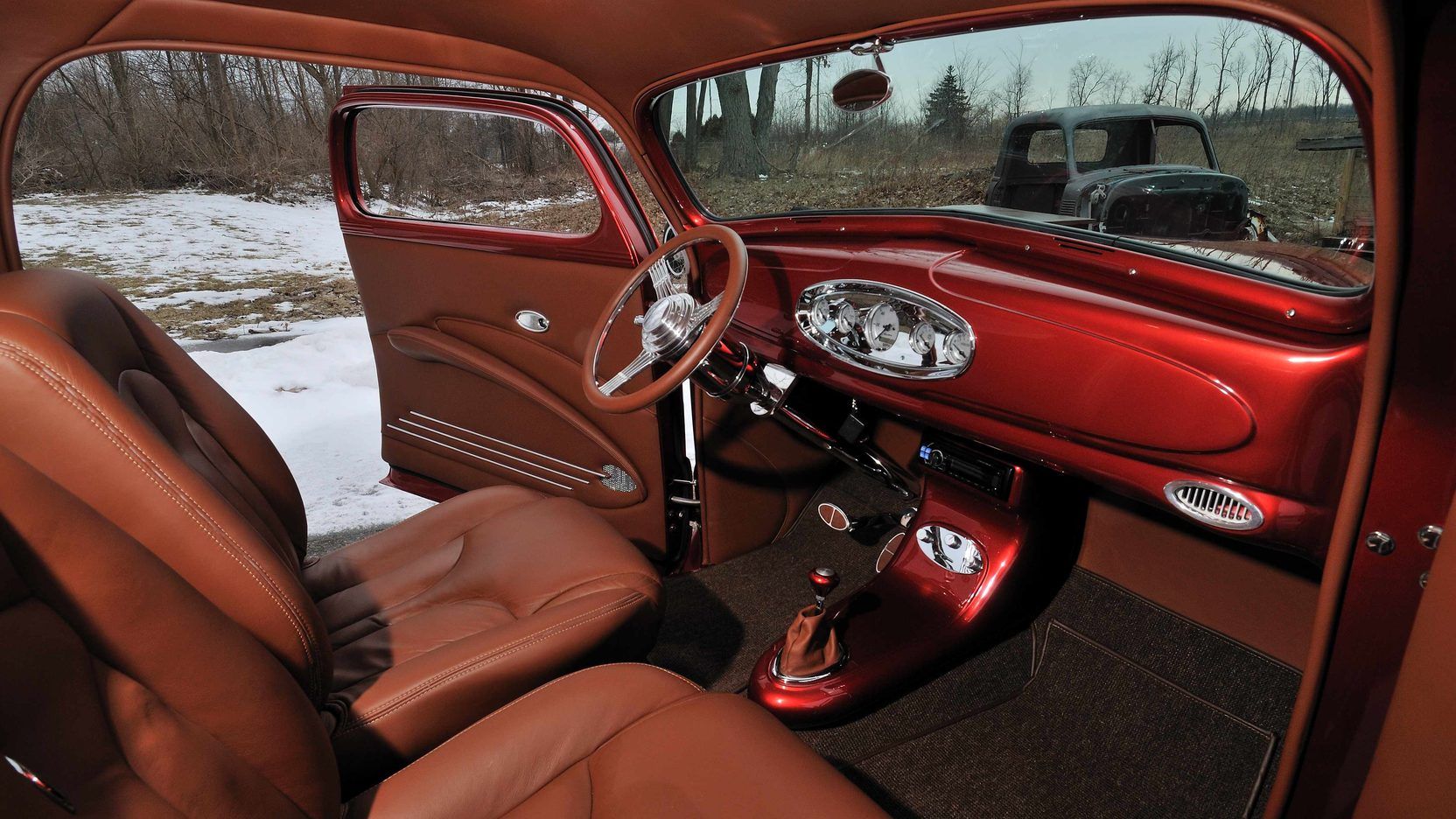 A red car with brown leather seats and a steering wheel.