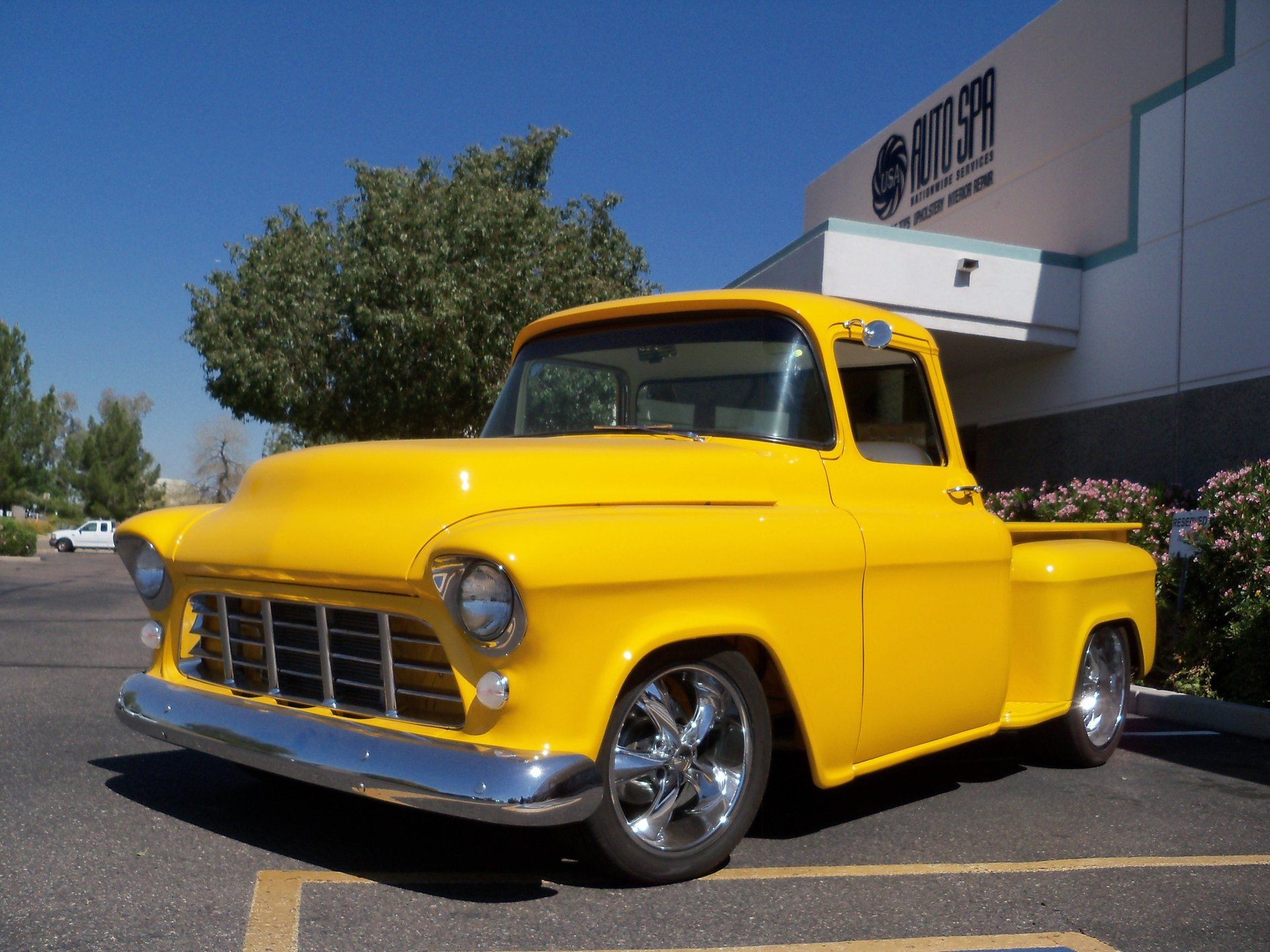 A yellow truck is parked in front of a building that says gateway.