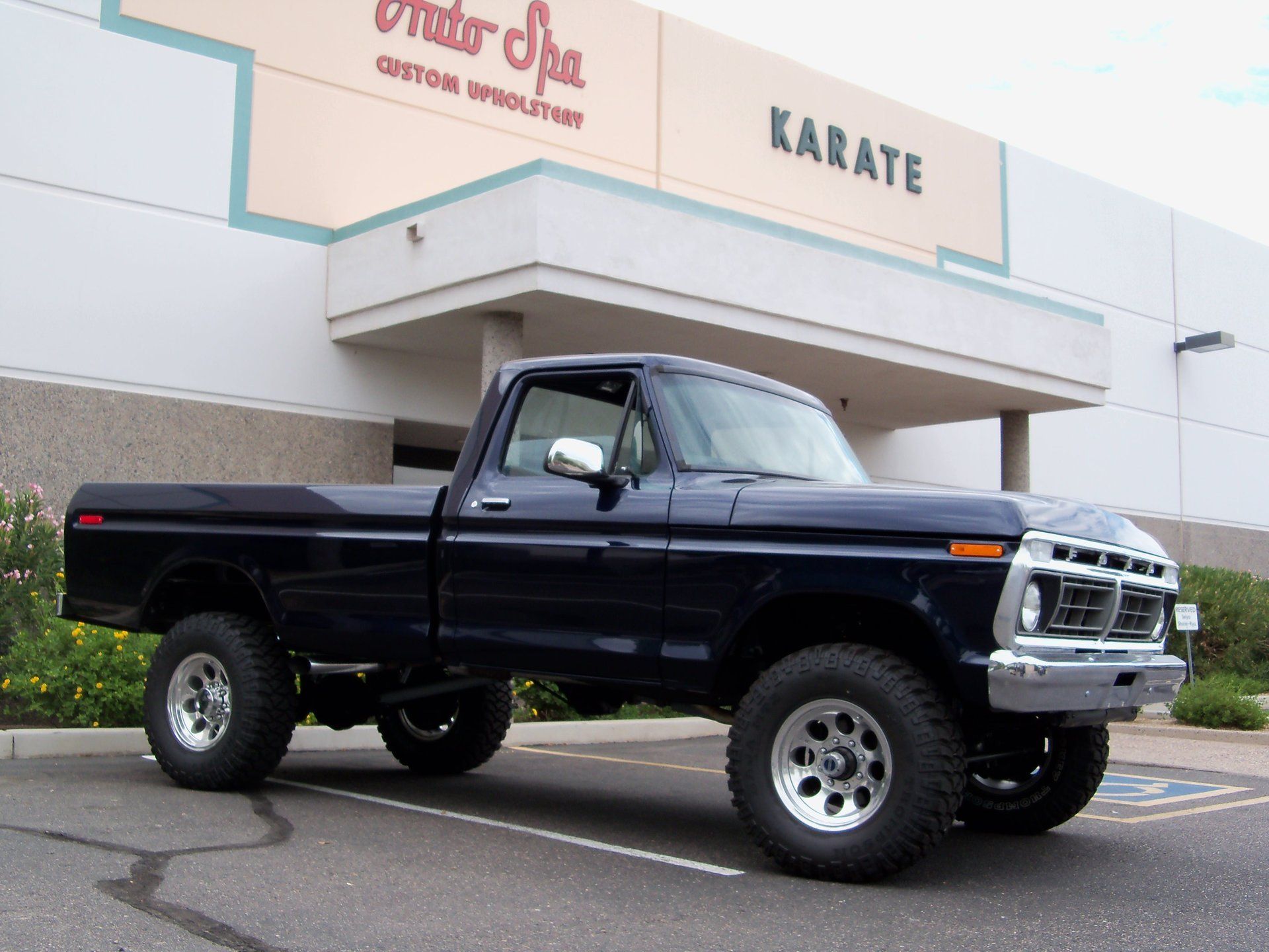 A black truck is parked in front of a building.