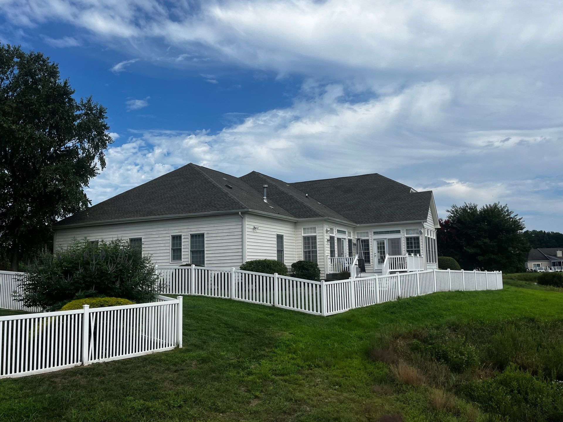A large white house with a white fence in front of it