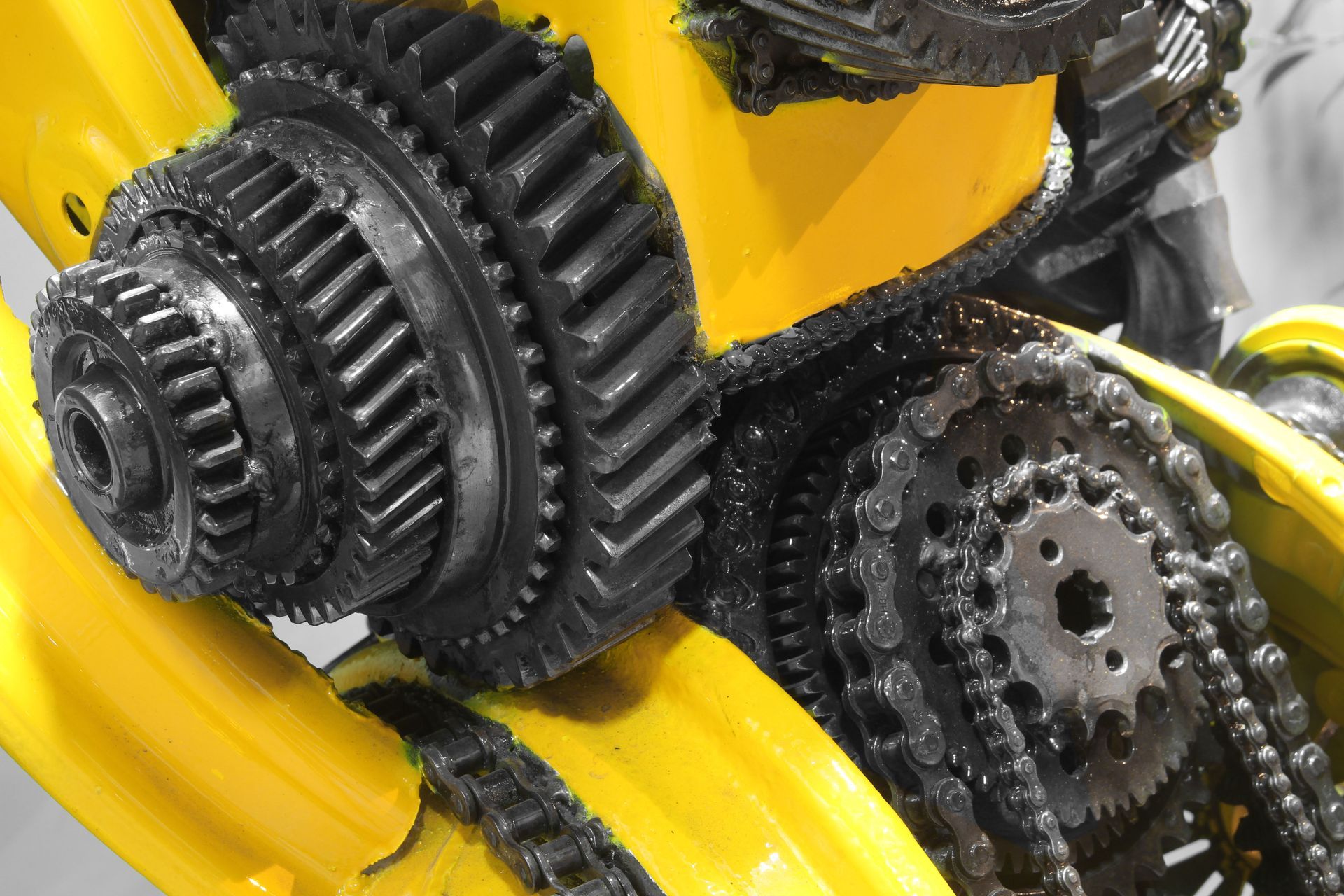 Close-up of black gears and a chain on a yellow robotic figure.