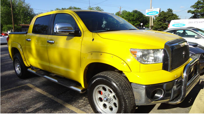A yellow truck is parked in a parking lot.