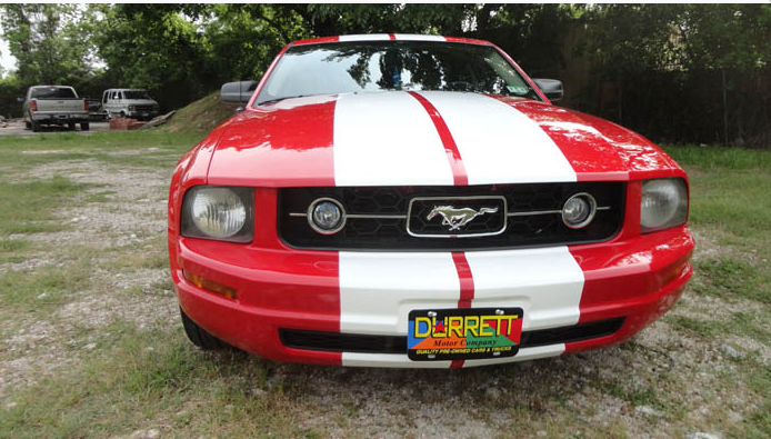 A red and white mustang with a current license plate