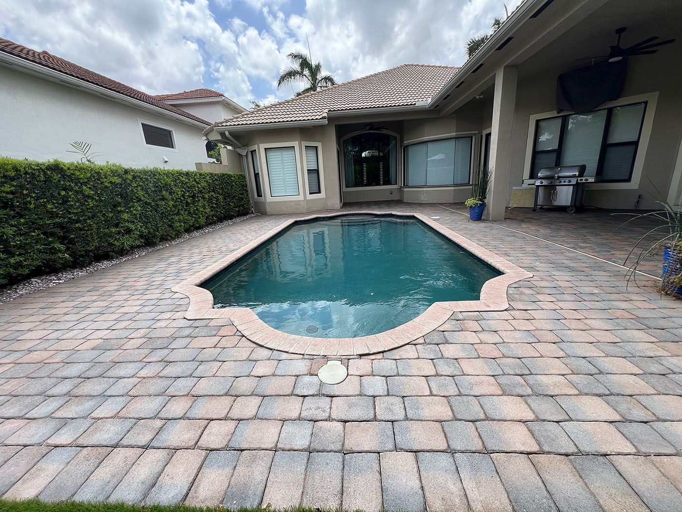 A swimming pool in the backyard of a house