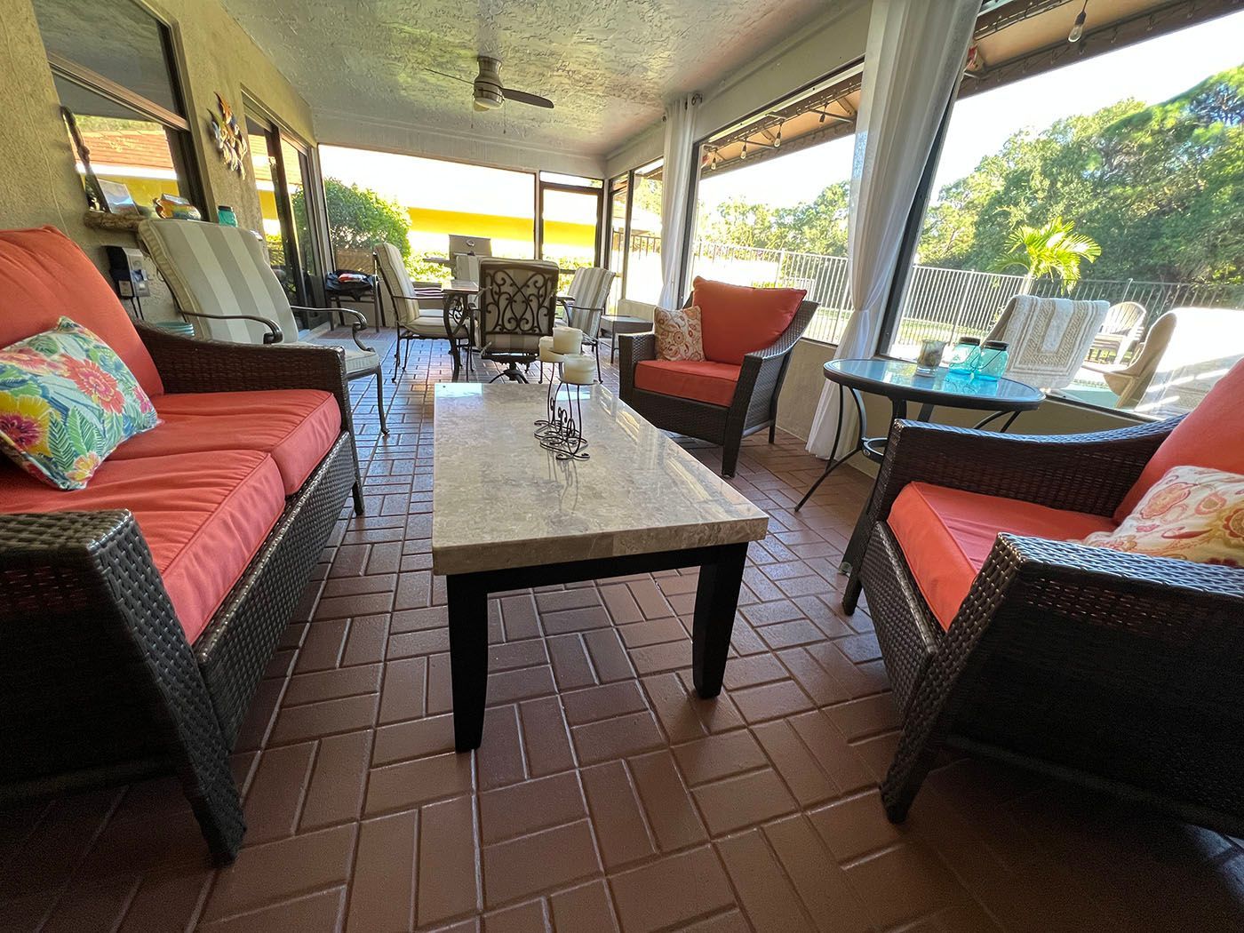 A screened porch with furniture and a coffee table