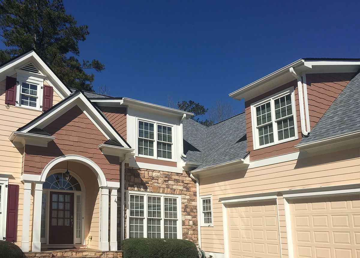 A large house with a gray roof and a red door.