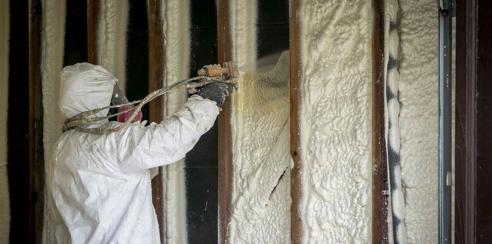 The back of a house with a large wooden deck and stairs.