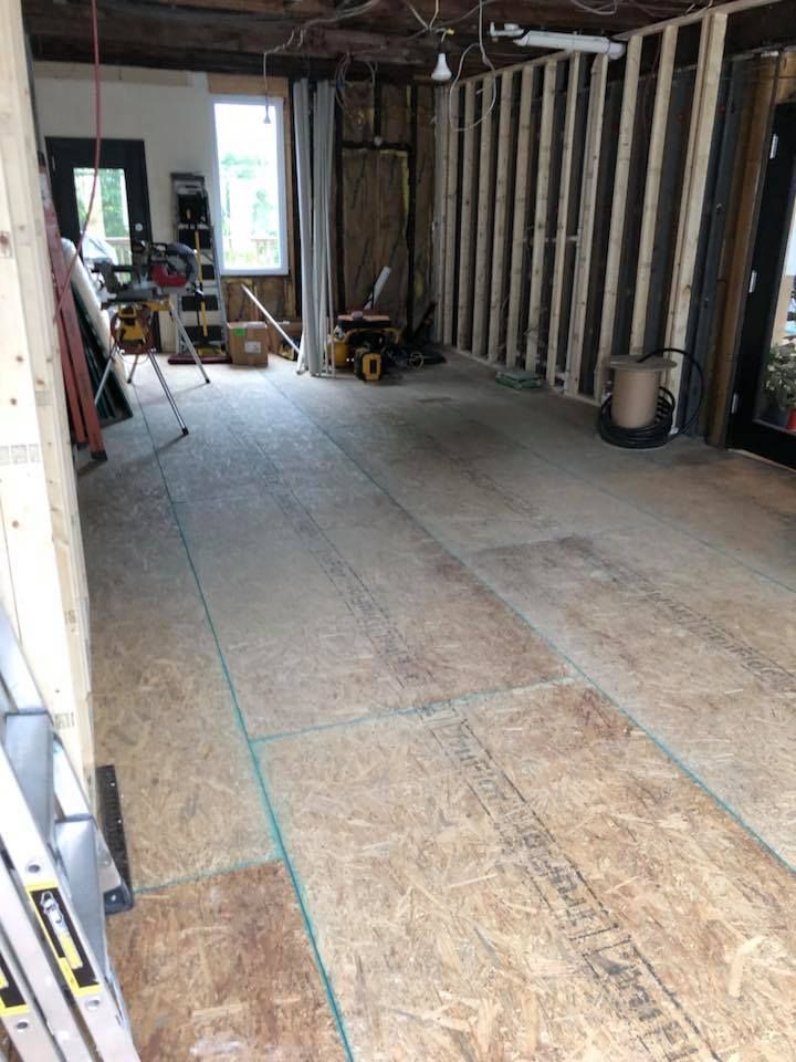 A room with a wooden floor and a ladder in it.