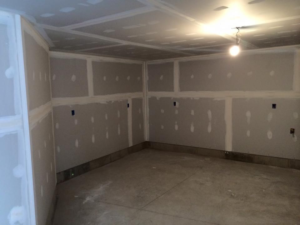 A room with drywall walls and a light on the ceiling.