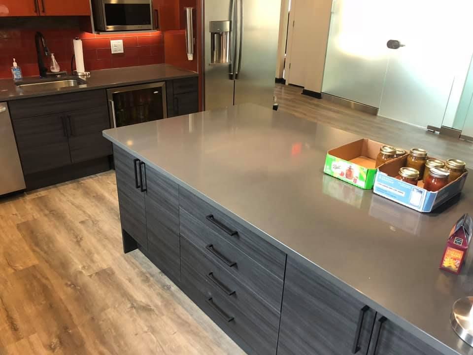 A kitchen with a large island and a box of jars on it.