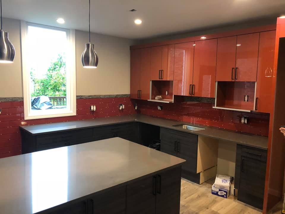 A kitchen with red cabinets and a large island in the middle.