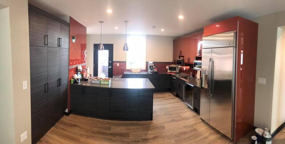 A kitchen with stainless steel appliances and red cabinets
