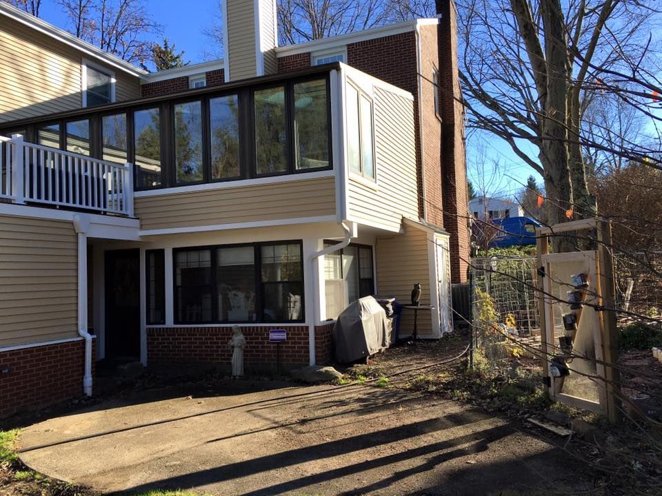 A house with a lot of windows and a driveway in front of it.