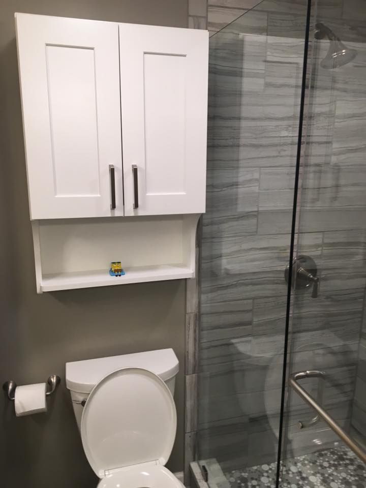 A bathroom with a toilet and a shower with a glass door.
