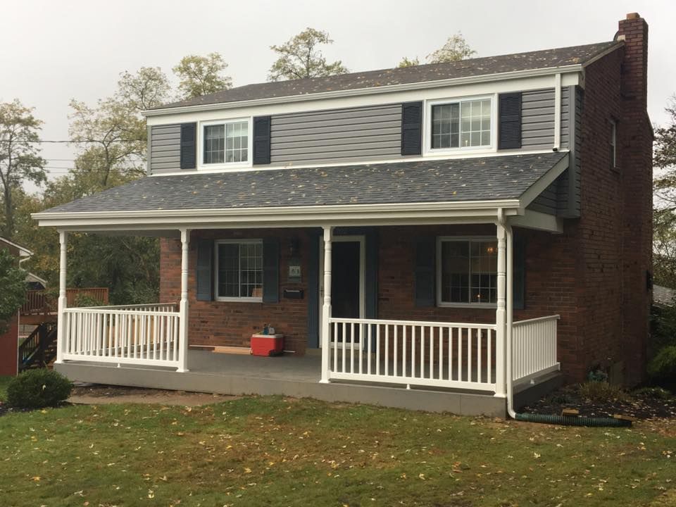 A brick house with a porch and a white railing