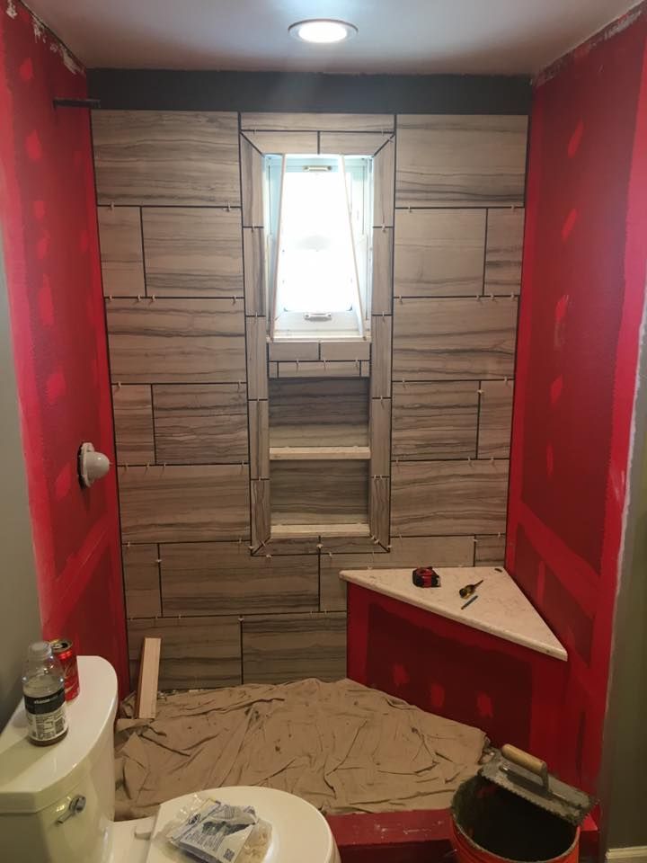 A bathroom with a toilet , sink and shower stall being remodeled.