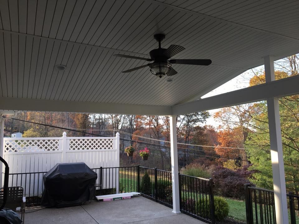 A patio with a ceiling fan and a grill.