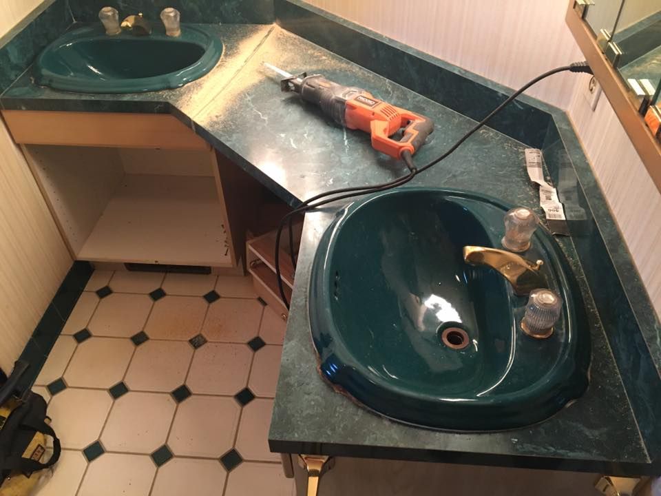 A bathroom with two sinks and a drill on the counter