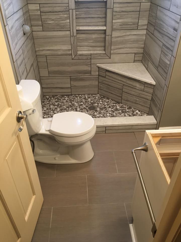 A bathroom with a toilet , shower , and sink.
