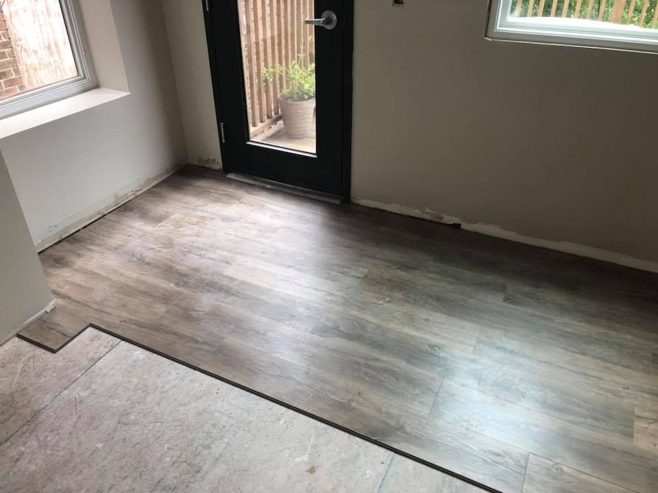 A room with a wooden floor and a sliding glass door.