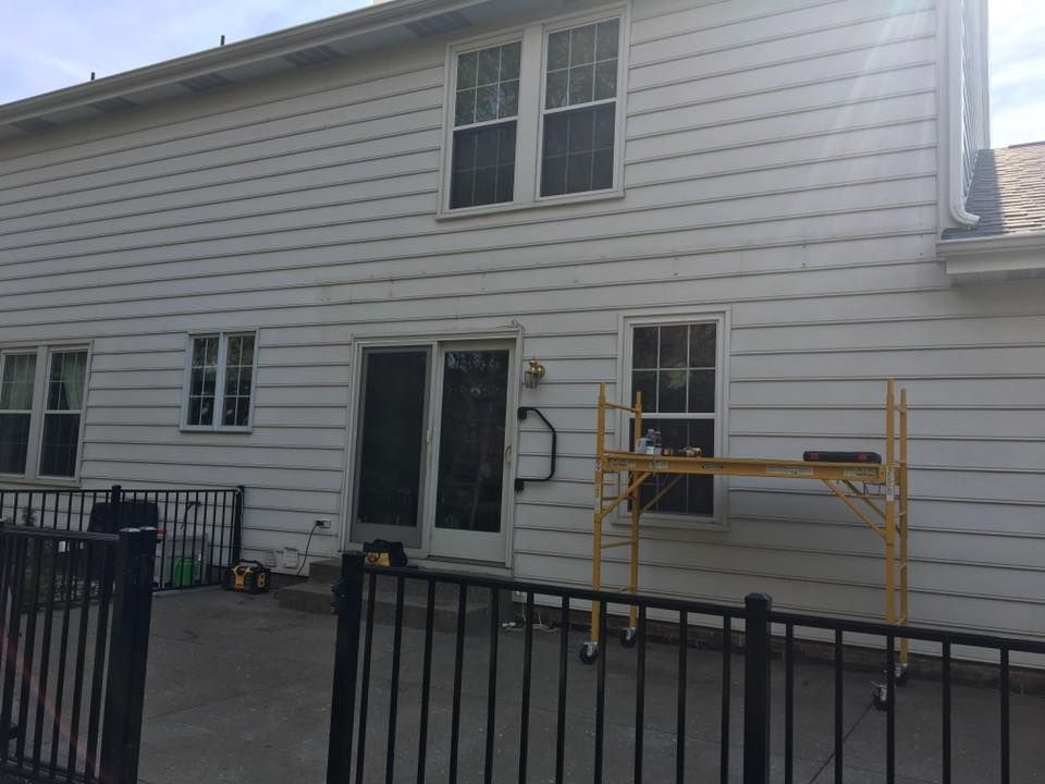 A white house with a yellow scaffolding in front of it.