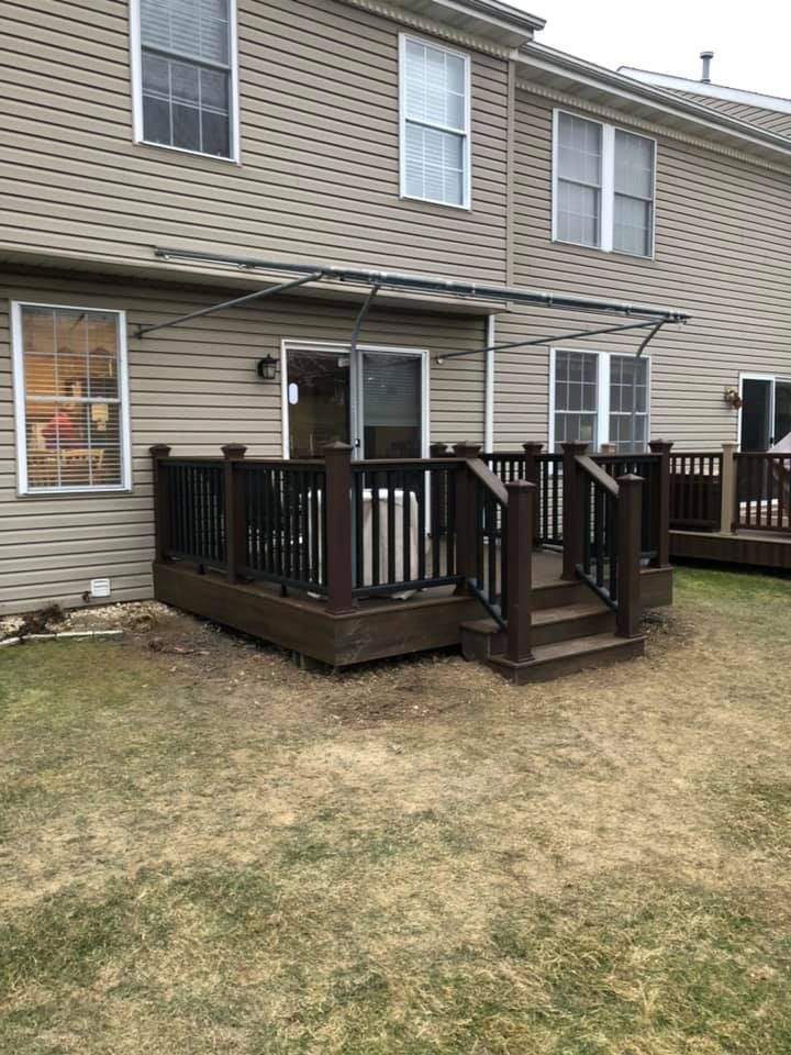 A house with a deck and stairs in front of it.