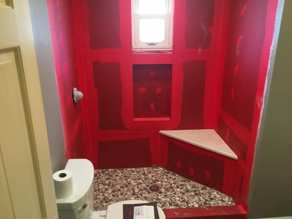A bathroom with red walls and a white toilet