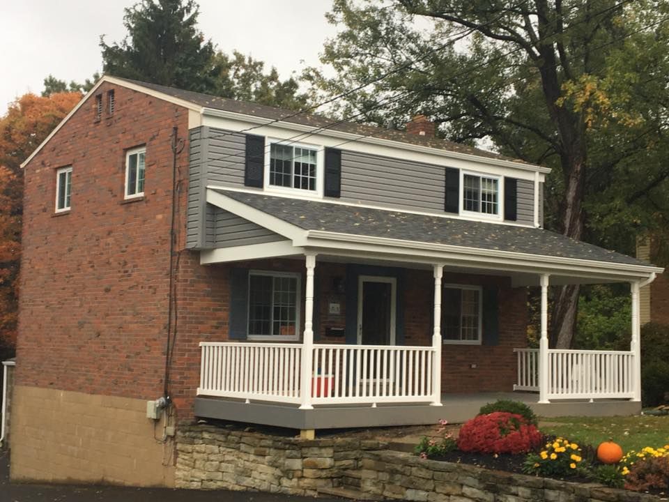 A brick house with a porch and a white railing