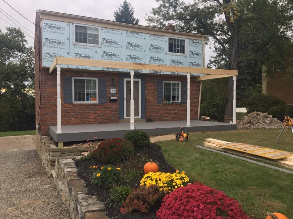 A house with a porch being built on top of it.
