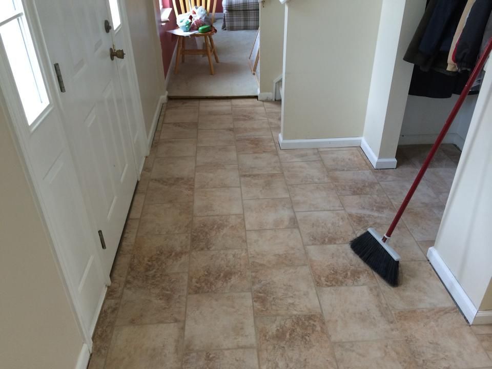 A hallway with tile floors and a broom on the floor