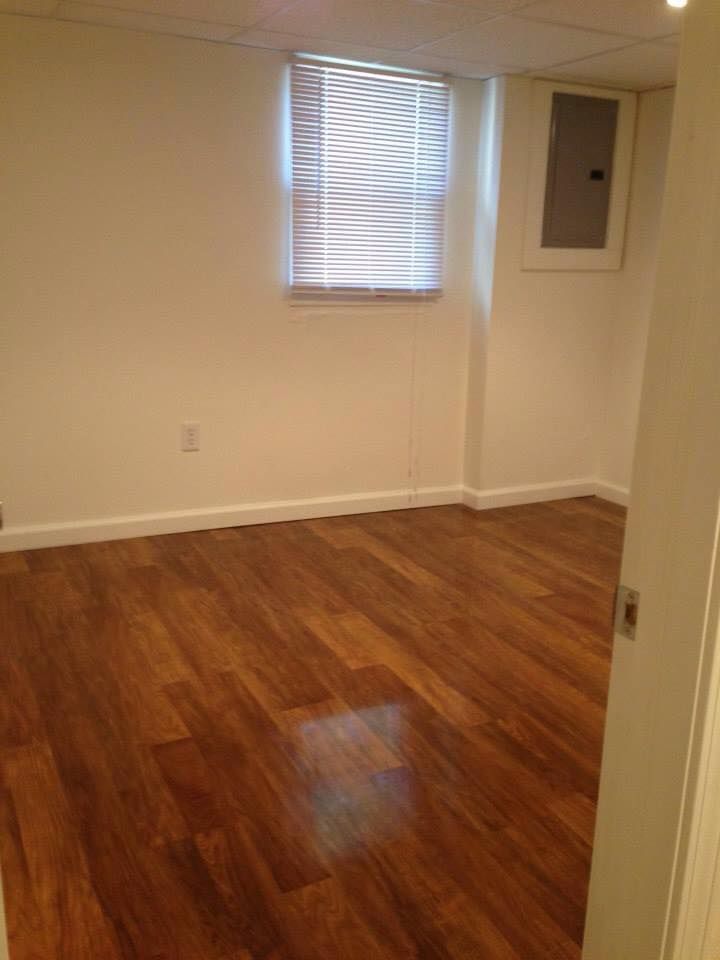 An empty room with hardwood floors and a window.
