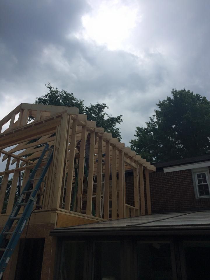 A house is being built with a ladder in front of it.